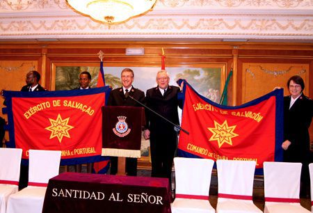 Commissioner Robert Street presents new Spain and portugal Command flags to Majors Mário and Celeste Nhacumba (Portuguese, left) and Lieut-Colonels Gordon and Susan Daly (Spanish)