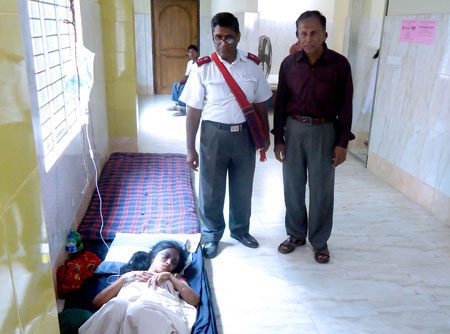 District Officer Captain Bibhudan Samaddar visits injured survivors in hospital, where medicine and beds are in short supply