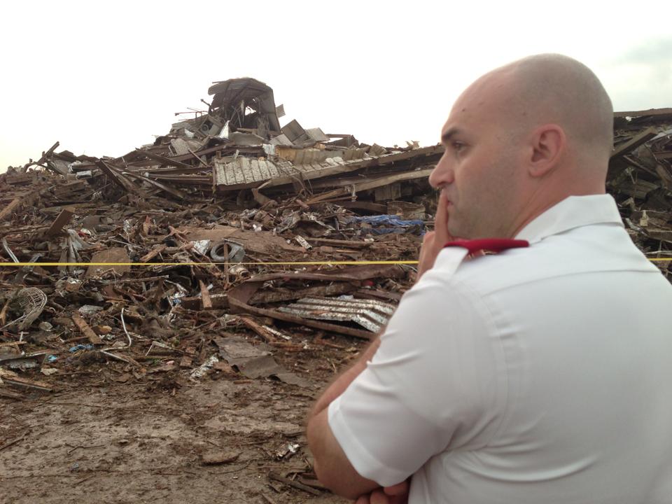 Salvation Army Officer looks over damage