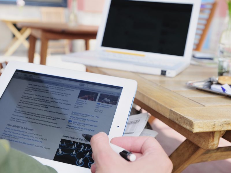 Person on iPad with laptop in front of them