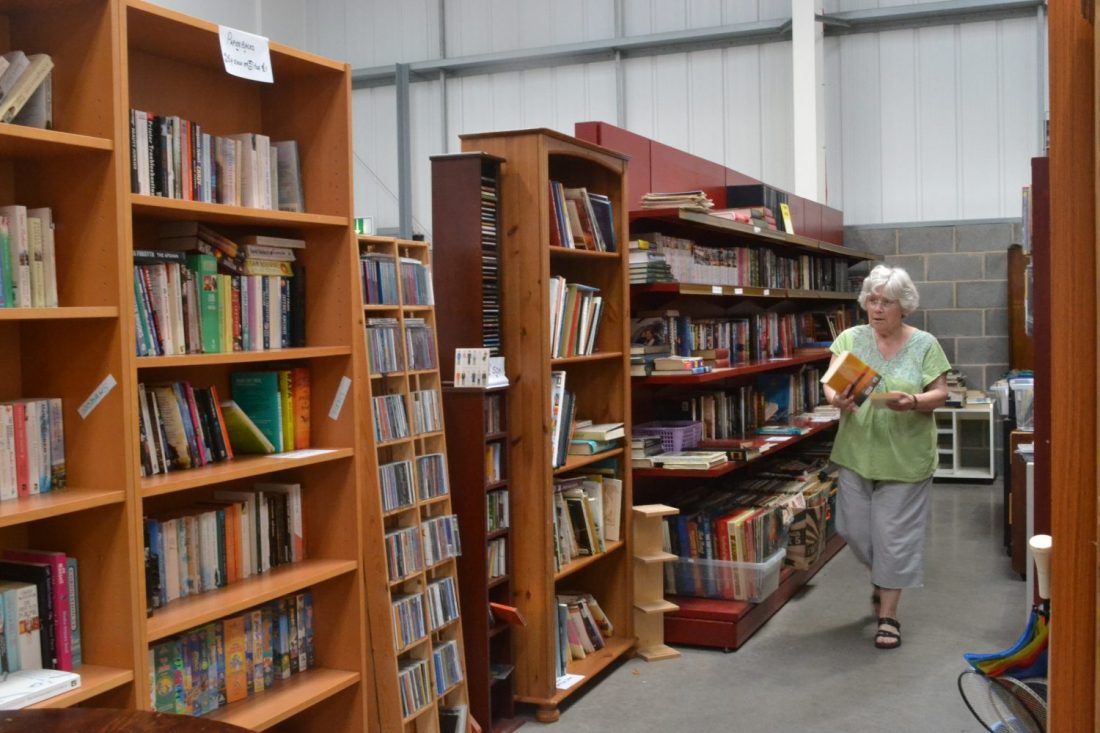 person walking by book shelves