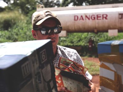 Sean Poole loads fliers, about LRA combatants who had successfully returned home, into a plane to drop over Uganda.