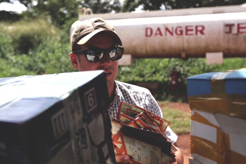 Sean Poole loads fliers, about LRA combatants who had successfully returned home, into a plane to drop over Uganda.