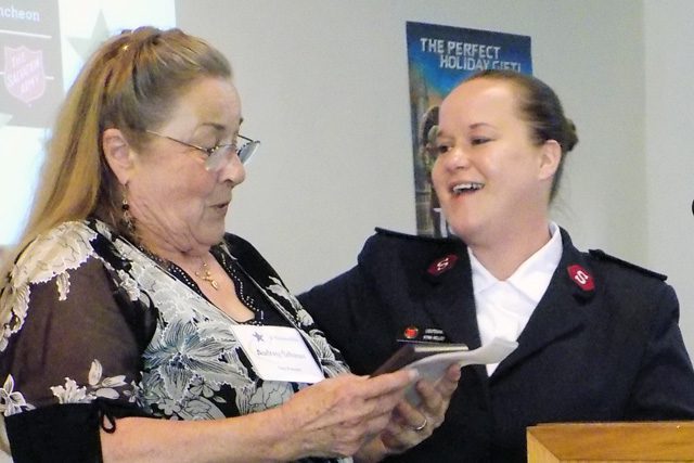 Long serving volunteer, Audrey Schauer, receives an award at the podium.