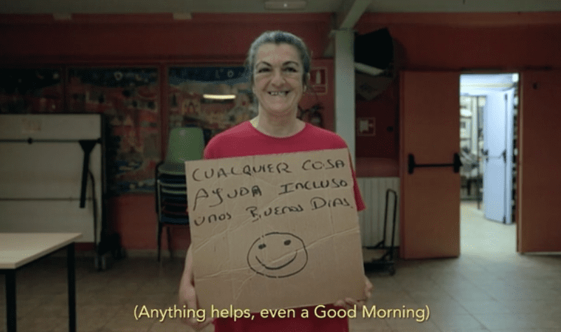 Homeless woman smiling with cardboard sign
