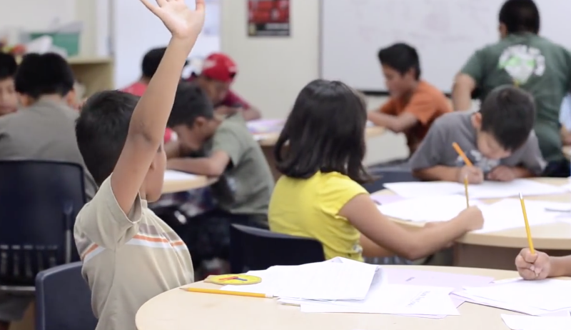 Child raising hand during class