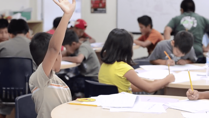 Child raising hand during class