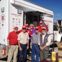 Men and Women standing in front of van