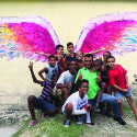 People posing in front of angel wings