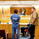 Person in prison jumpsuit in courtroom
