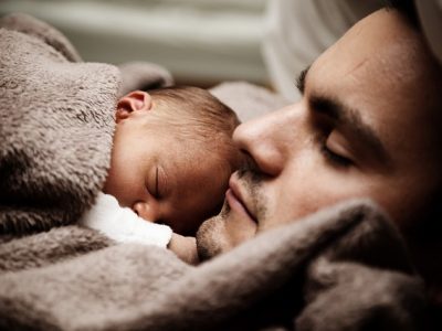 Man with baby sleeping on chest