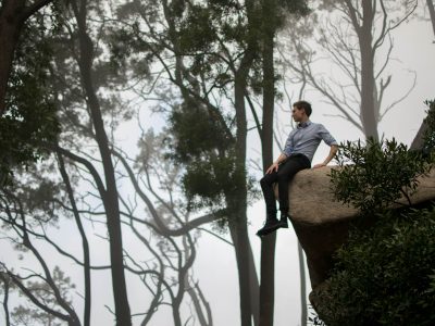 Man sitting on edge of cliff