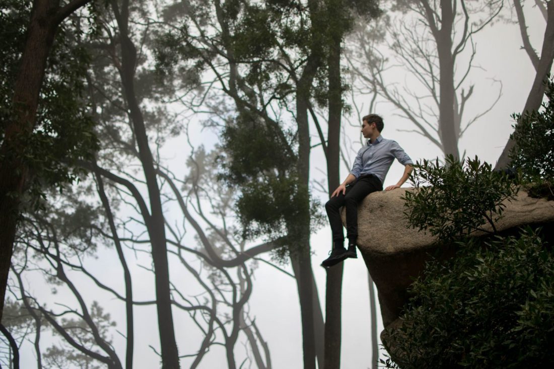 Man sitting on edge of cliff