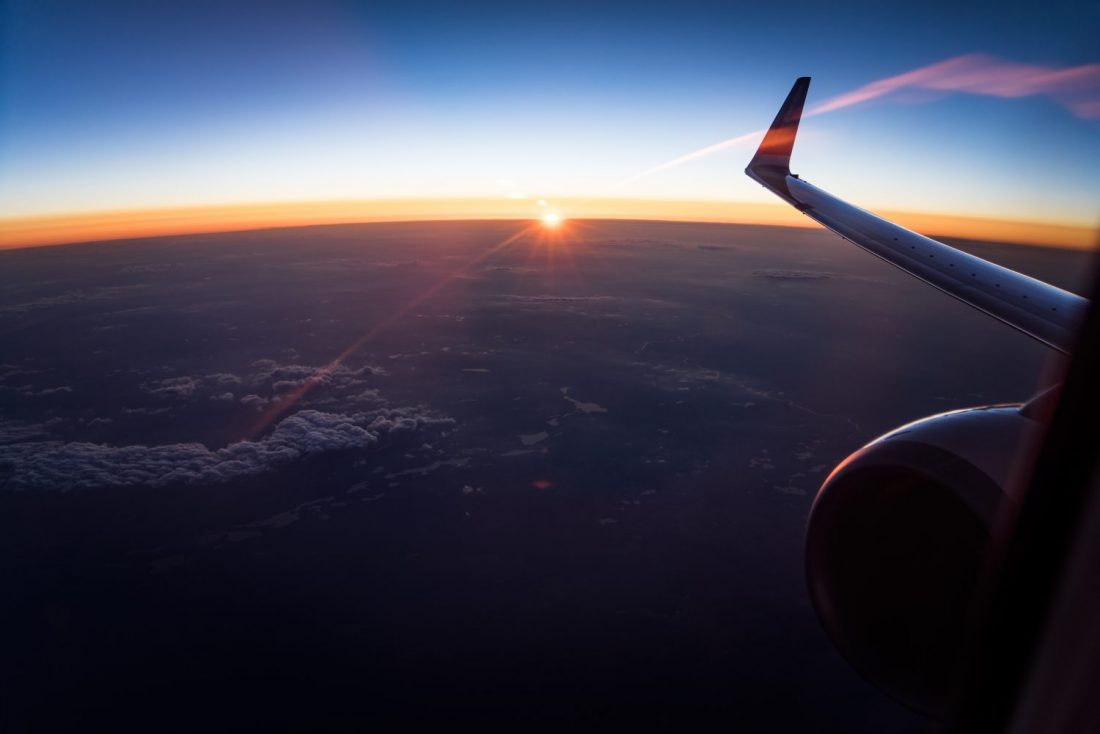 View above clouds with airplane wing