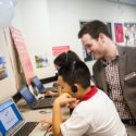 Child on computer with teacher
