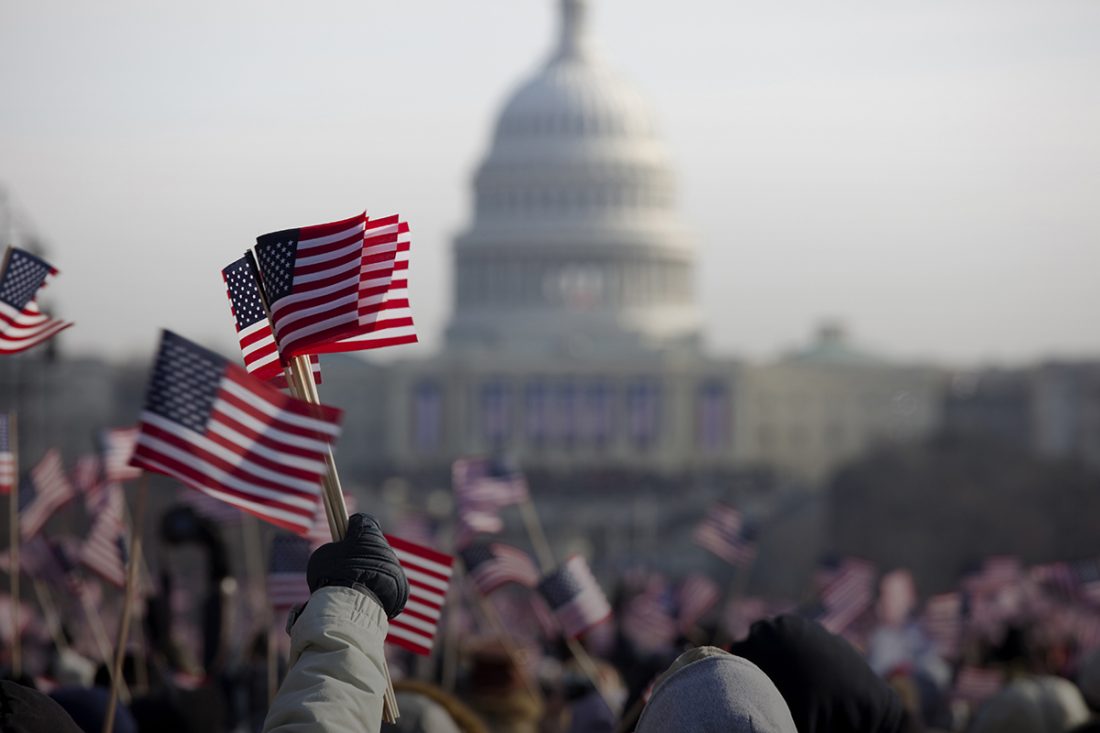 People waving miniature flags at the capitol building