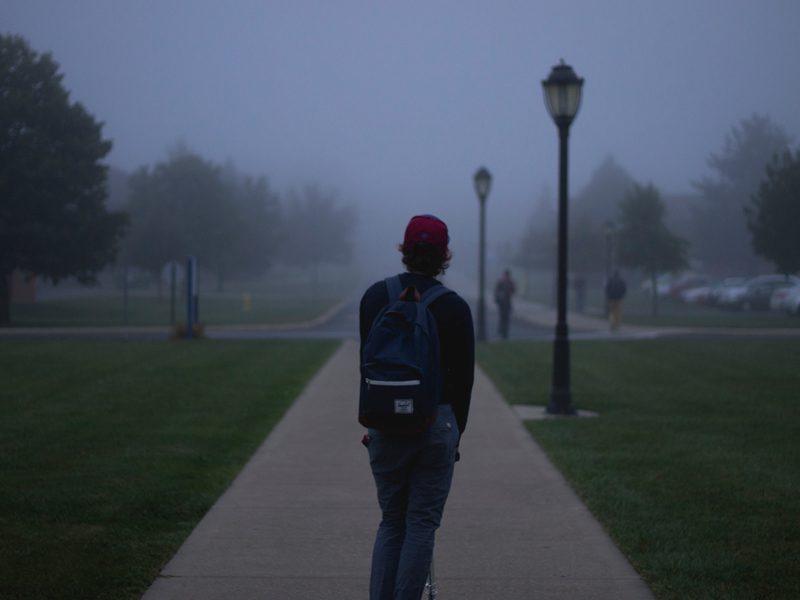 Person walking with backpack outside