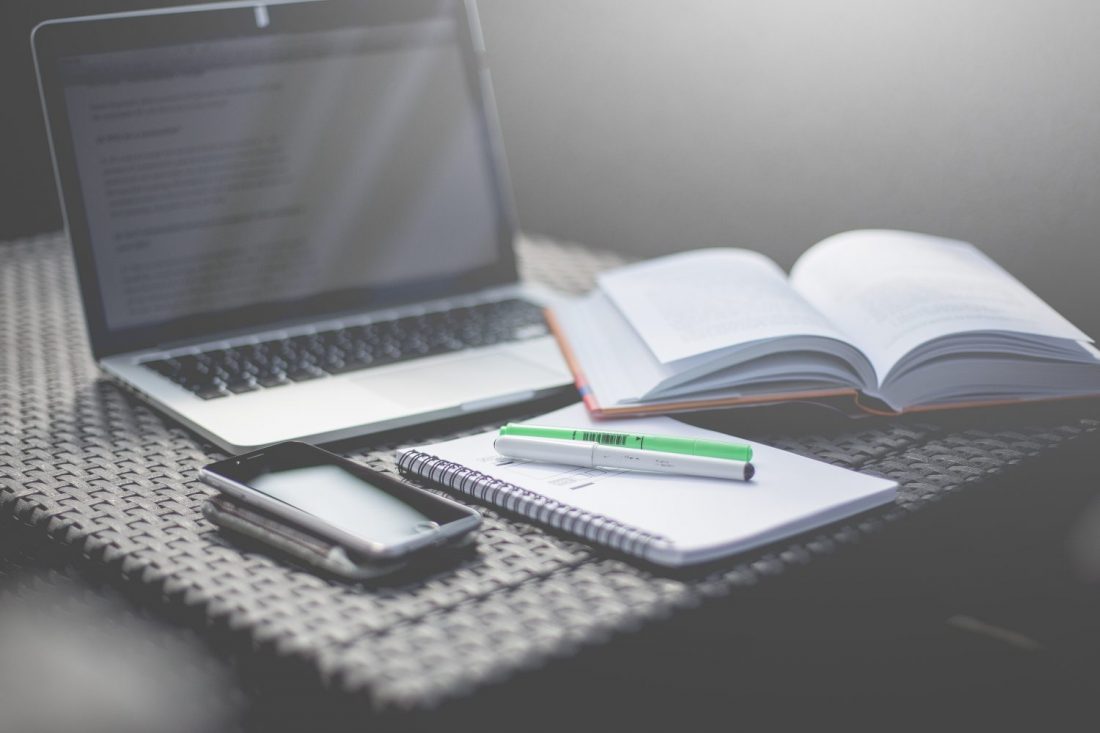 laptop with book and pens