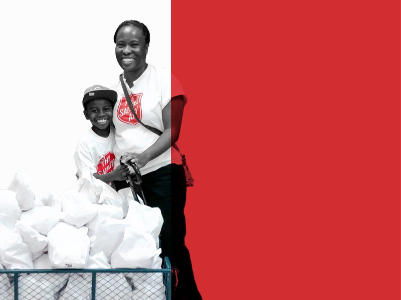 Mother and son smiling with each other in Salvation Army shirts