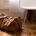 Duffel bag on ground next to chair