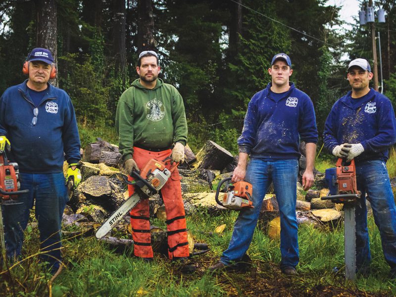 Four men outside with chainsaws
