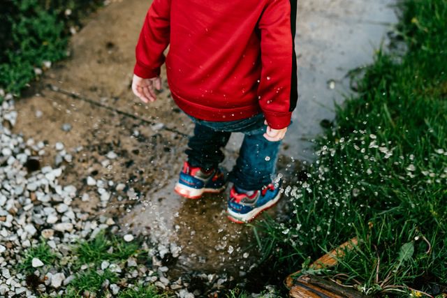 Child in red jacket jumping outside