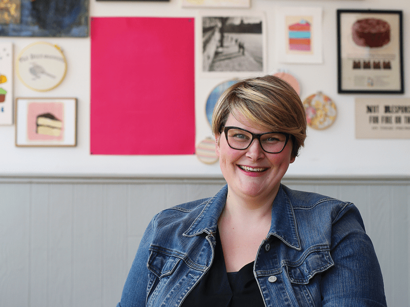 Woman smiling with jean jacket and glasses