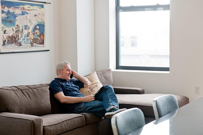 Man sitting on couch talking on phone