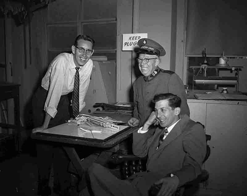 Three men smiling at table