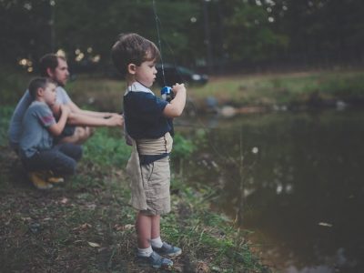 Child holding camera by pond