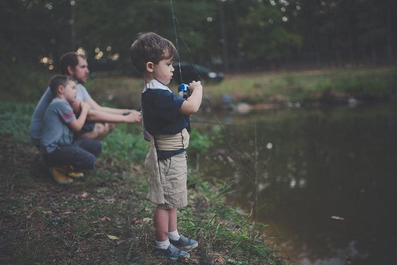 Child holding camera by pond