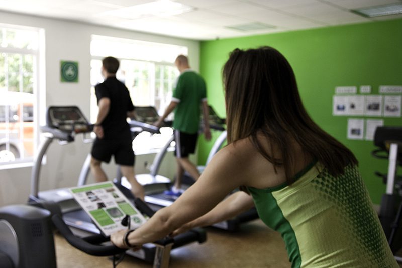 people exercising on treadmills and stationary bike