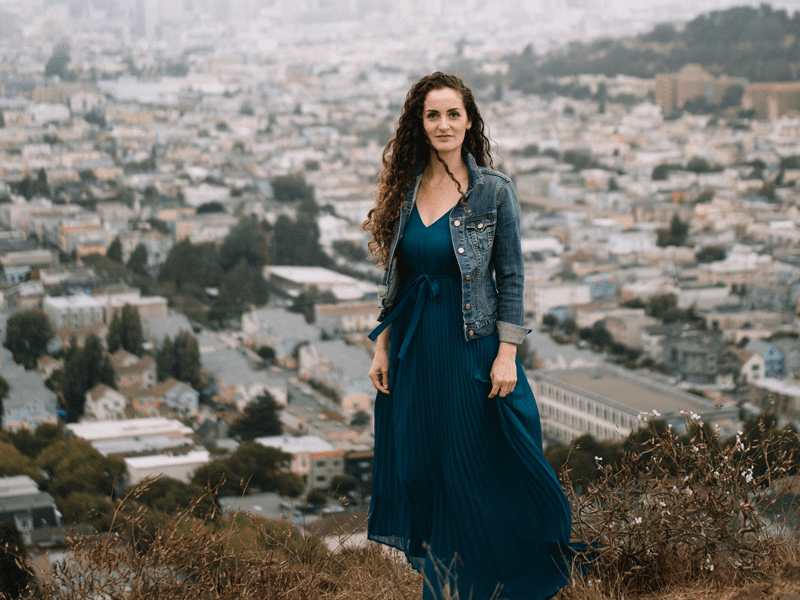 Woman standing on hill above city
