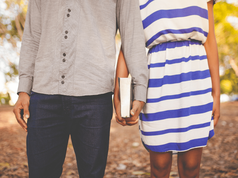 Man and woman holding book together