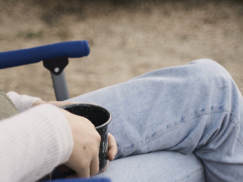 person sitting in chair holding cup