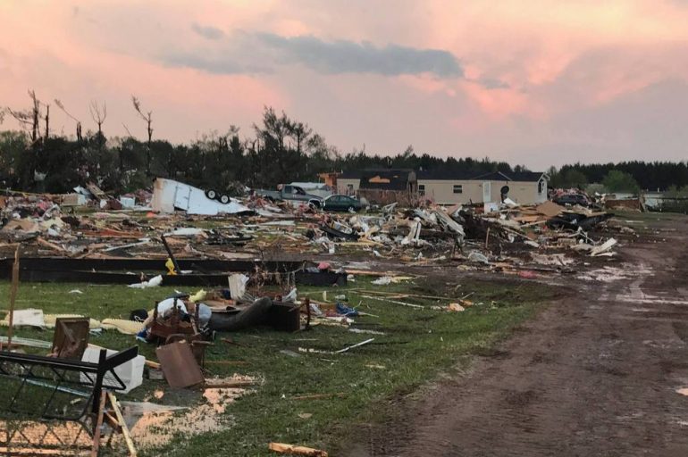 Volunteers pause to pray for the families impacted by the tornadoes that ripped through Wisconsin on May 17