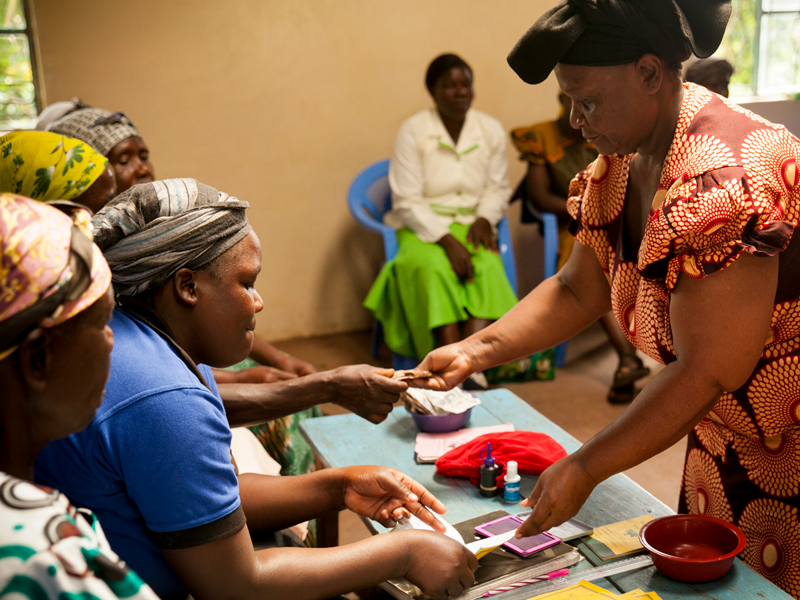 Woman handing paper to younger girls