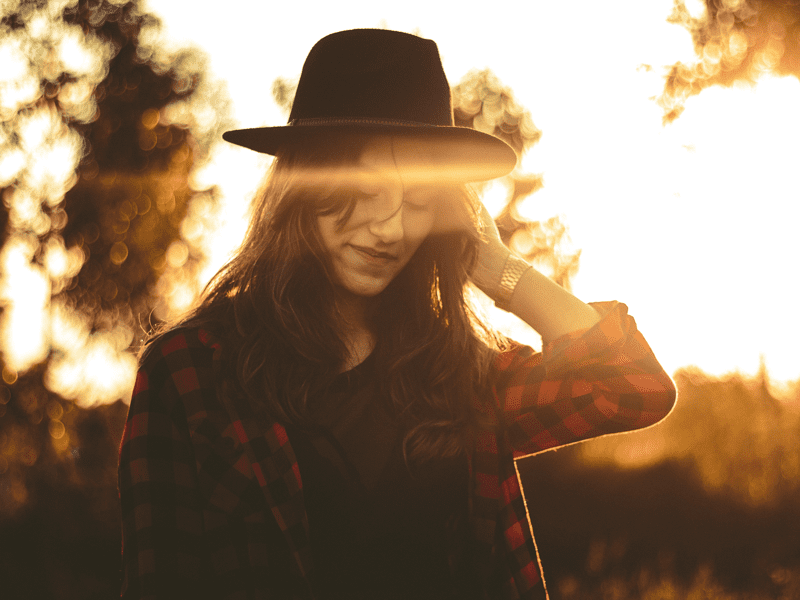 Woman with hat looking down and smiling