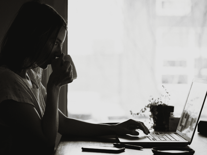 Person drinking coffee while on computer