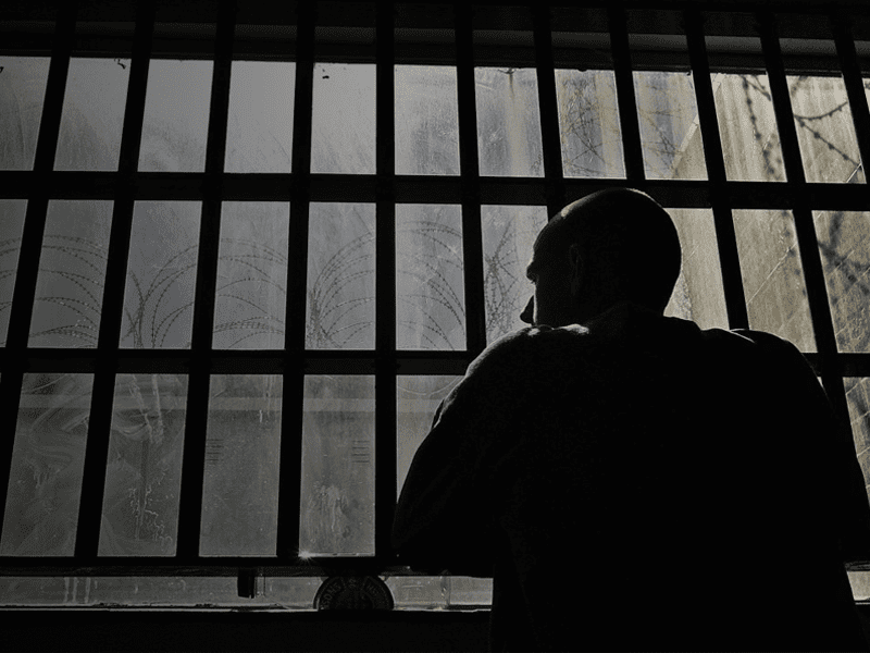 Man looking out window in dark room