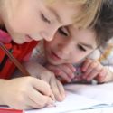 two young children writing