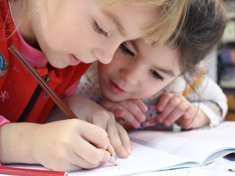 two young children writing