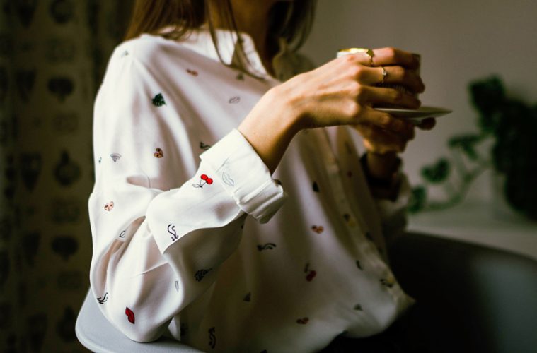 woman holding coffee cup with two hands