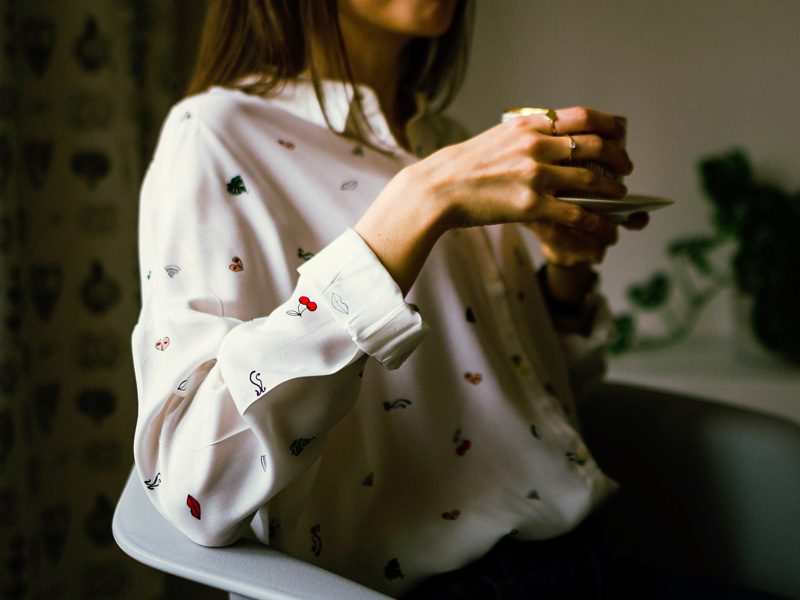 woman holding coffee cup with two hands