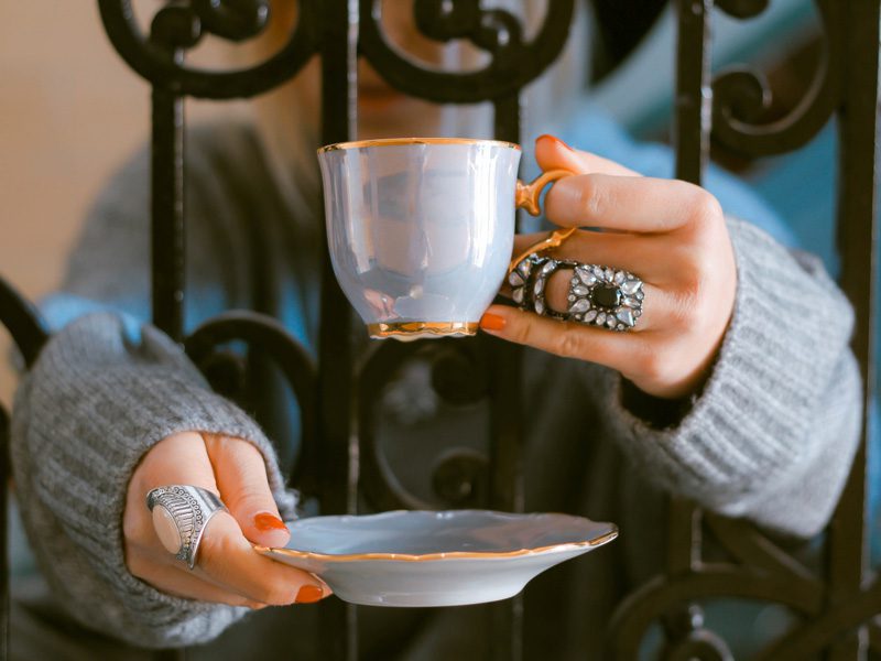 hands holding cup and plate