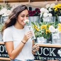 Woman smiling while smelling flower