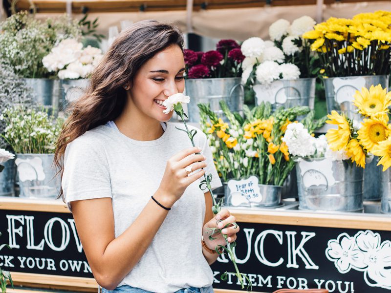 Woman smiling while smelling flower