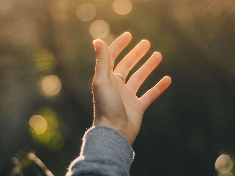 hand with ring reaching up to sky