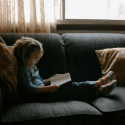 young girl reading on couch