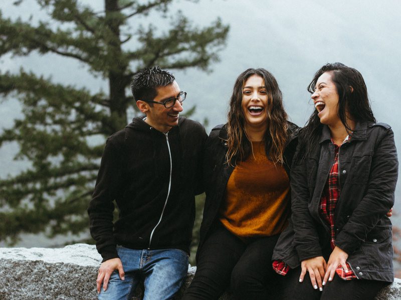 Three people laughing together outside